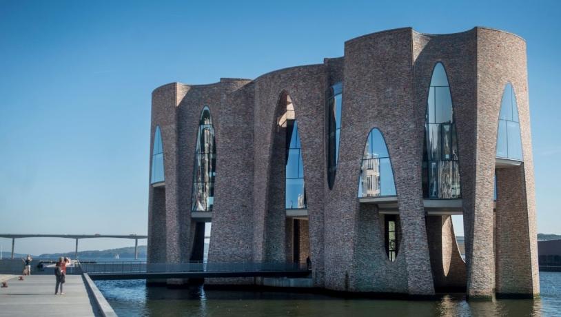 Fjordenhus på en sommerdag med blå himmel og Vejlefjordbroen i baggrunden