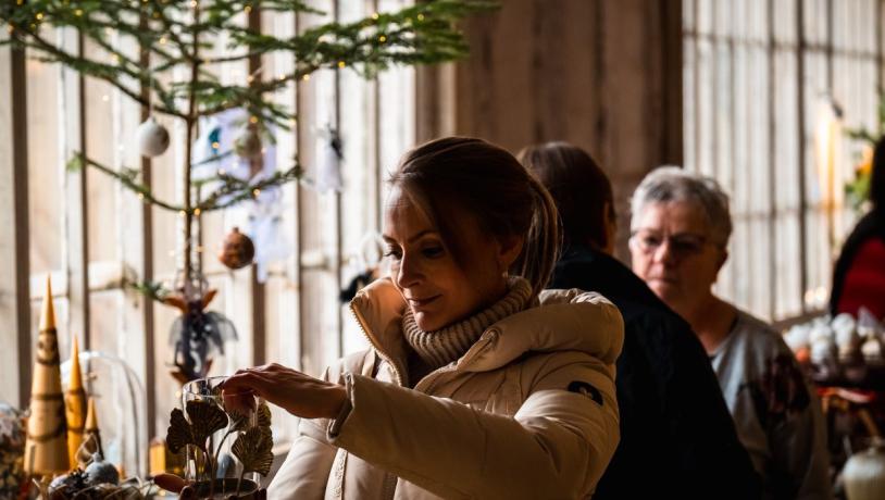 Kvinde kigger på julepynt ved Tirsbæk Gods' julemarked 