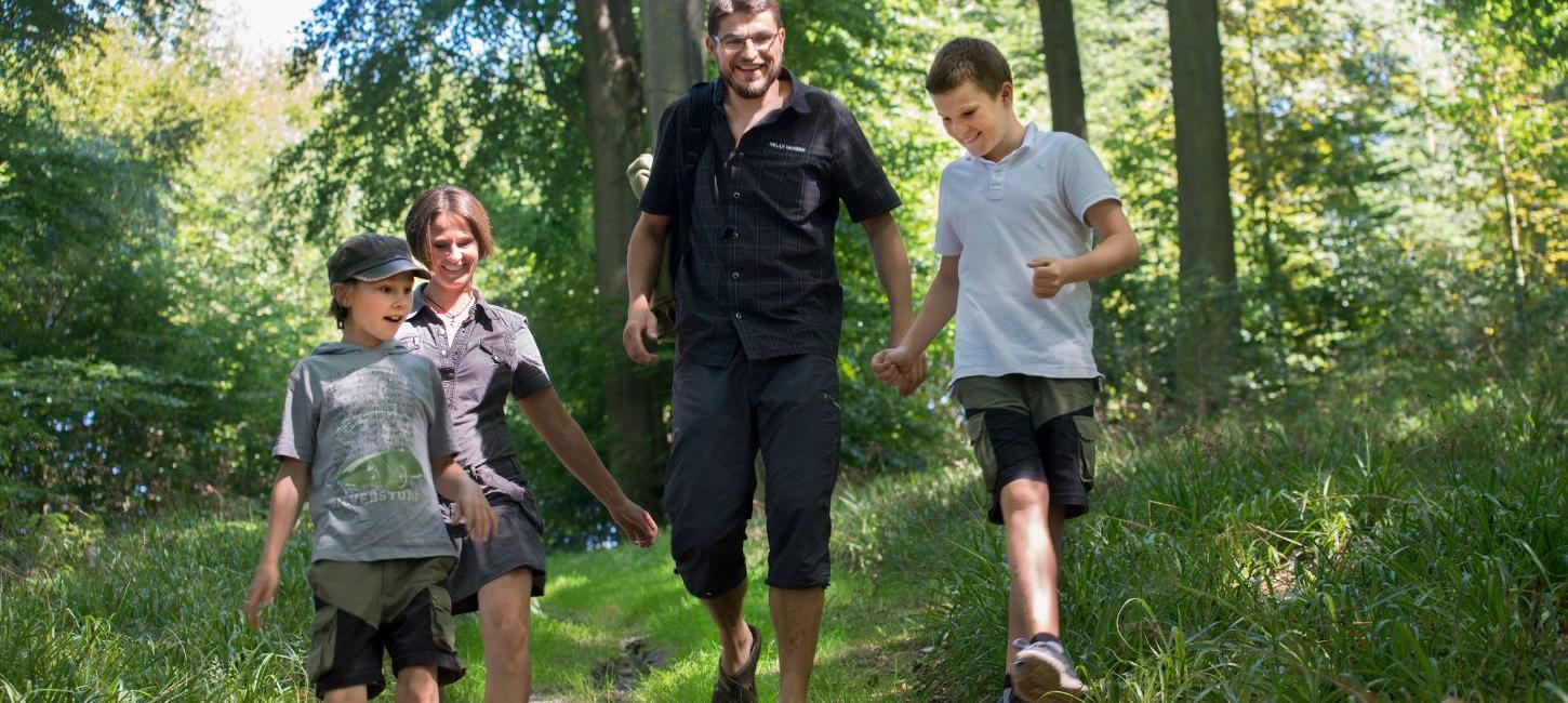 Familie på tur i Munkebjergskoven en sommerdag