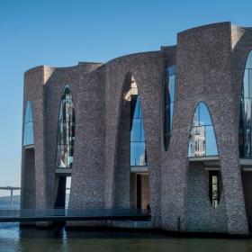 Fjordenhus på en sommerdag med blå himmel og Vejlefjordbroen i baggrunden